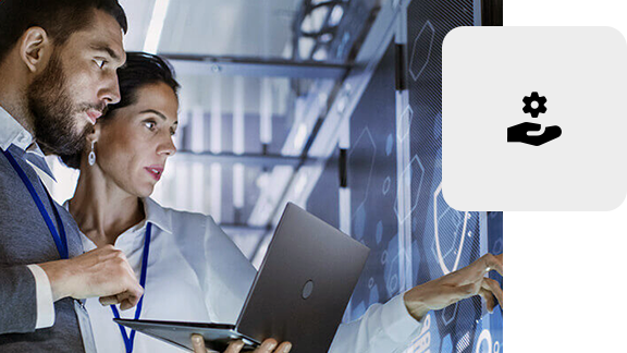 IT specialists working with a laptop in front of a server cabinet