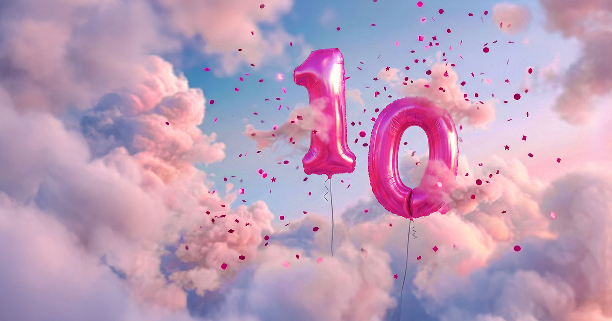 2 magenta balloons and confetti in a cloudy sky