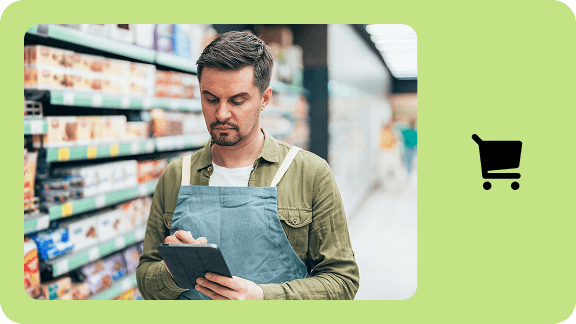 Retail employee checking inventory with a tablet in a supermarket.