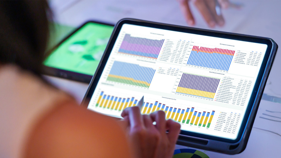 Sustainability Dashboard Businesswoman analyzing an ESG dashboard with charts and key figures on a tablet computer using a stylus.
