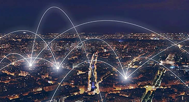 Weiße Verbindungslinien zwischen Häusern einer Stadt bei Nacht