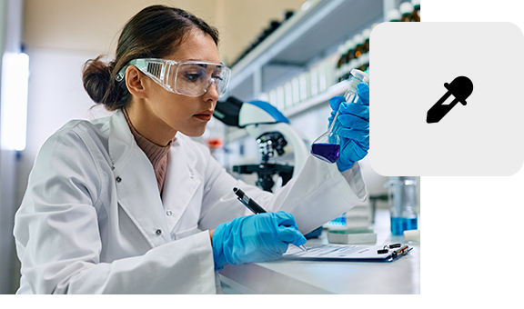 Lab technician performing chemical analysis with a pipette and protective gear.